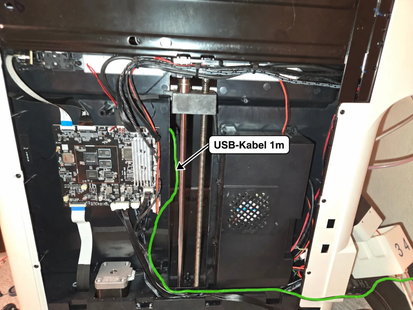 Blick in die Rückseite des Druckers mit Platine und Kabeln. Eine grüne Linie markiert den Weg eines 1 Meter langen USB-Kabels.